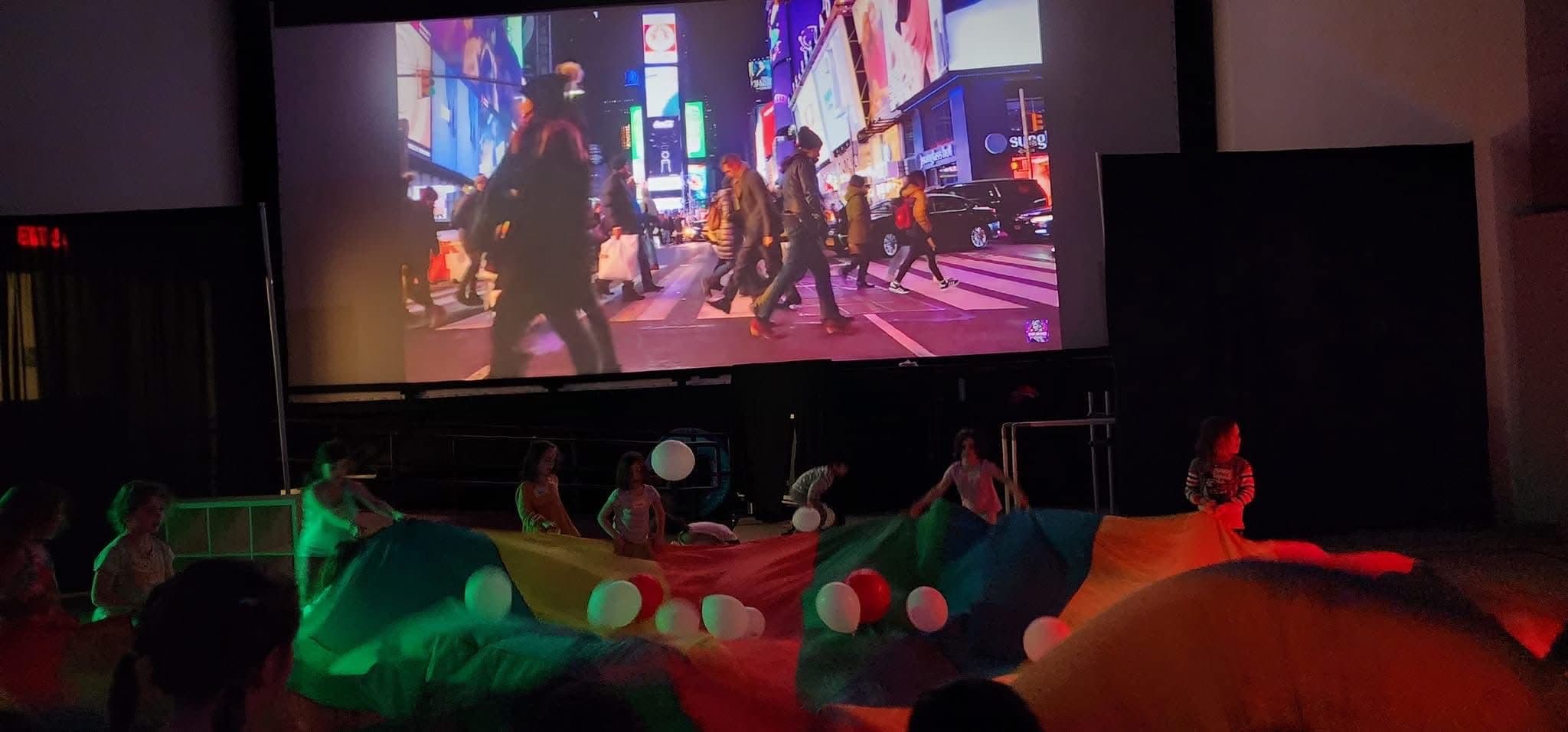 Children under a parachute during a party show finale