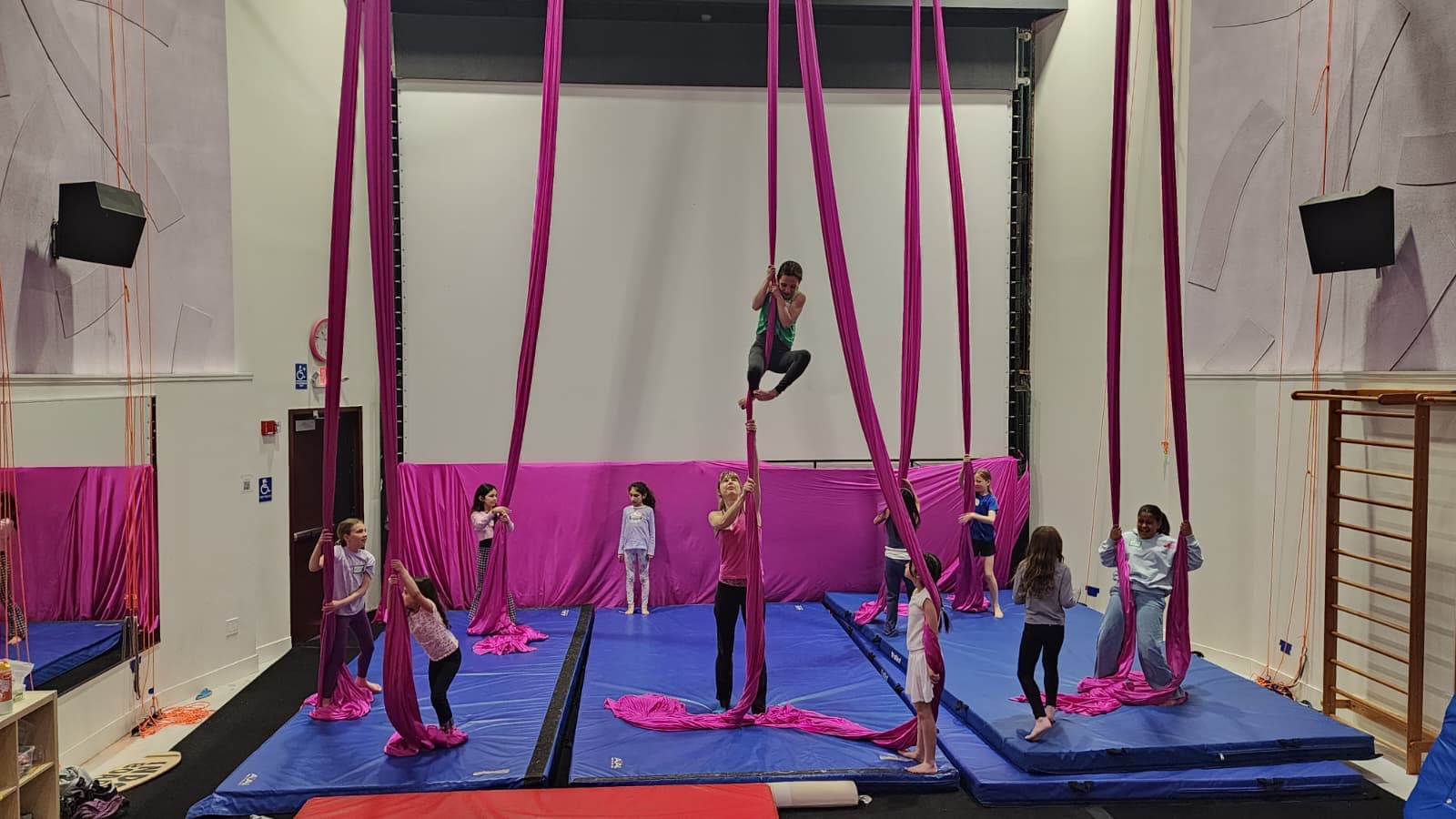 Campers exploring aerial silks during a creative camp workshop